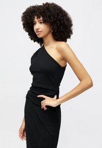 Must have ühes õlas top, millel on sobiv disain ja volditud kangastehnika. Sile tekstuur, minimalistlik kuju ja elegantne siluett.