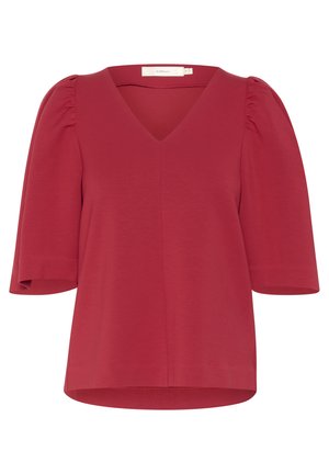 Raudona trumpomis rankovėmis palaidinė, pagaminta iš elastingos medžiagos, su V formos iškirpte ir pūstomis rankovėmis. Lygi tekstūra, šiek tiek laisvas siluetas.