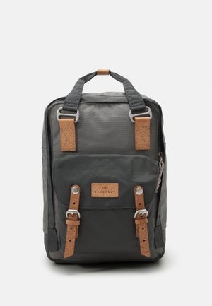 Szürke hátizsák bőráthúzattal, fémalkatrészekkel, elülső zsebével, rögzítőkkel, téglalap alakú és texturált anyagból készült.