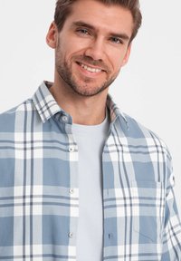 Lichtblauw geruit overhemd van katoen, met grote witte en donkerblauwe blokken, button-down kraag en een borstzak.