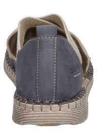 Scarpa slip-on blu in pelle con foderatura in canvas beige, cuciture a vista e suola testurizzata, caratterizzata da un accento cucito attorno al tallone.