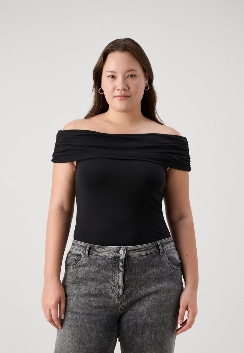 Μαύρο κορμάκι εκτός ώμου με ρυάκωση στην περιοχή του λαιμού, συνδυασμένο με ψηλόμεσα ξεθωριασμένα γκρι τζιν με μπροστινές τσέπες.