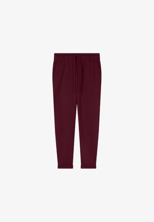 Bordowe dresy z elastycznym pasem, sznurkiem do regulacji i bocznymi kieszeniami. Zwężany krój nogawki z gładką, miękką fakturą.