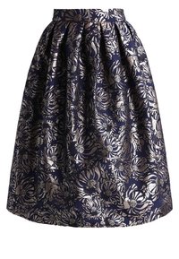 Námořnická modrá sukně s květinovým stříbrným vzorem, vybavená přiléhavým pasem a nabíranou strukturou pro objem. Vyrobena z lehkého materiálu.