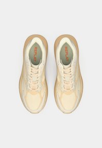 Beige treningssko med teksturert overflate, tonale snøringer og gummisåle. "REPLAY" merkevare i oransje på innersålen.