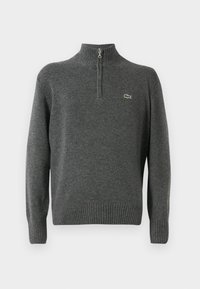 Halliga pullover-sviiter pooltõmblusega, ribatatud varrukate ja äärega, valmistatud pehmest kangast. Rinna peal on väike roheline Lacoste logo.