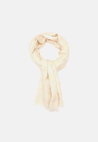 Lys beige tørklæde med et subtilt mønster, blød tekstur og frynset kanter. Designet i en sløjfeform.