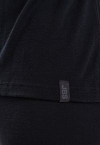 Black cotton t-shirt featuring a smooth texture, a straight hem, and a small JBS label stitched on the side.
