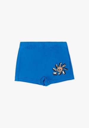 Blauwe kinder zwemshort met elastische tailleband en een afbeelding van een teddybeer omringd door dikke letters op één been.