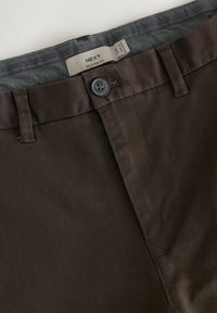 Pantaloni marroni a vestibilità comoda con chiusura a bottone, caratterizzati da una cintura intrecciata in un motivo di tessuto a contrasto. Materiale resistente con finitura morbida.