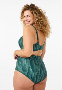 Žalias bikinis aukštu liemeniu su lapų raštu. Savybė - raukiniai prie viršaus ir reguliuojamos petnešėlės. Sklandus, tekstūruotas audinys.