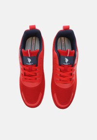 Rote Sportschuhe mit einem Netz-Obermaterial, einer strapazierfähigen Gummisohle und einem Schnürdesign. Merkmale einen dunkelblauen Akzent am Kragen und einem Logo-Patch.