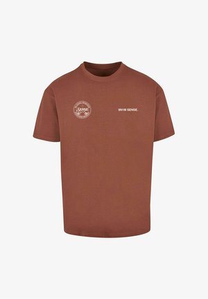 Pruun puuvillane t-särk ümmarguse kaelusega. Omab valgeid trükitud graafikuid: logo vasakul rinnal ja "9N1M SENSE." ees.