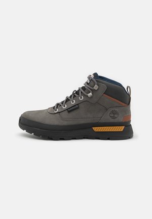 Gray hiking boot with a textured leather upper, rubber sole, reinforced toe, metal eyelets, and a brown accent on the heel.