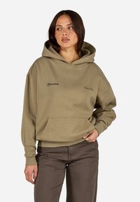 Olivgrüner Hoodie aus weichem Stoff, mit einer Fronttasche, verstellbarem Kordelzug und bedruckten Logo-Akzenten.