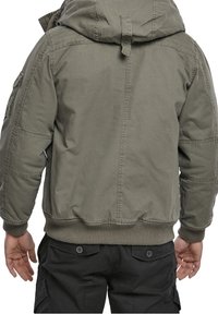 Zielona bawełniana kurtka z kapturem, ściągaczami przy mankietach i dolnym brzegu, wyposażona w boczne kieszenie i prosty tył.
