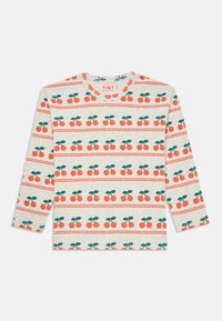 Long-sleeve beige shirt with repeating cherry pattern in red and green, labeled "TINY" on the inside collar.