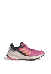 Zapatilla de trail running Adidas Terrex, parte superior de malla rosa y negra, media suela de EVA, suela de goma, tres rayas naranjas, cuello acolchado.