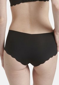 Mutande nere a vita alta con bordo ondulato e texture liscia, caratterizzate da un design semplice e minimalista, senza marchi o motivi visibili.