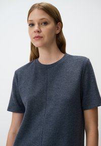 Kurzärmliges, dunkelgraues T-Shirt mit Rundhalsausschnitt, aus weichem Stoff, mit subtiler Textur und einem durchgehenden Nahtdesign.