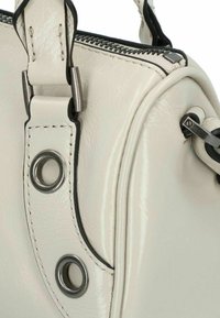 Borsa a mano in pelle bianca con finitura lucida, dotata di dettagli neri, accessori in metallo e cuciture vicino alla tracolla e alla cerniera.