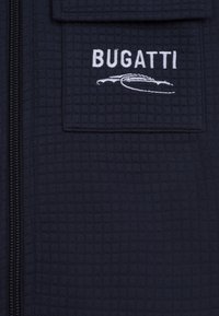Giacca a zip navale in tessuto testurizzato, dotata di tasca sul petto e logo "BUGATTI" ricamato in bianco con silhouette di un'auto.