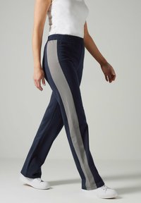 Marine joggers met een elastische tailleband, voorzien van grijze zijstrepen en een ontspannen pasvorm. Gemaakt van zachte stof met een gladde textuur.