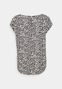 Blouse à manches courtes, noire avec un imprimé léopard blanc, dotée d'une fermeture éclair au dos. Le tissu est léger, lisse et légèrement texturé.