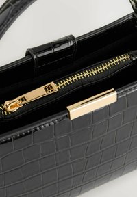 Černá kabelka s hadí texturou a elegantním designem. Obsahuje zlatý zip a kování, a krátké ucho pro snadné nošení.
