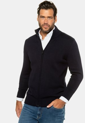 Navy Zip-Cardigan aus Strickstoff. Verfügt über einen gerippten Kragen und Bündchen, mit einer glatten Textur und figurschmeichelndem Design. Wird über einem Hemd mit Kragen getragen.