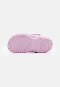 Pink rubber shoe sole with textured tread pattern and raised sections for grip. Rounded shape with a smooth, matte finish.