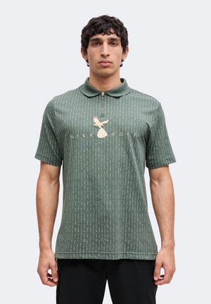 Uomo che indossa una polo verde a maniche corte con motivo, con zip e logo "Nike Golf" con un uccello e una pallina da golf.