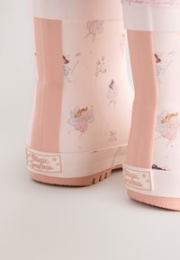 Stivali da pioggia rosa in gomma con un motivo fiabesco di fate, suole testurizzate e punte arrotondate con etichetta "Magica Scintilla".