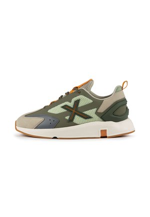 Sneaker sportivo verde e grigio con tomaia in rete, accenti in suede, lacci arancioni e una soletta bianca spessa con suola in gomma.