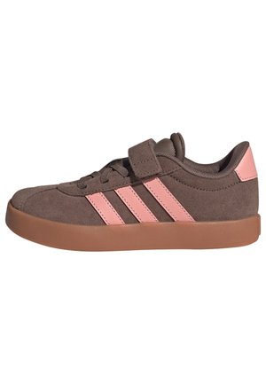 Zapatilla de ante marrón con rayas rosas, parche rosa en el talón, una correa de velcro y suela de goma.