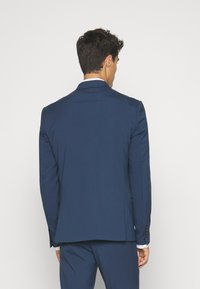 Navy blue suit jacket with a tailored fit, single vent at the back, and button accents on the sleeves, made from smooth fabric.