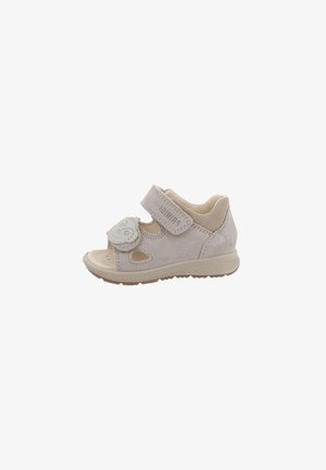 Sandalo beige per bambino piccolo con ritagli, due cinturini regolabili con velcro, uno decorato con una toppa a forma di volto sorridente, e una suola in gomma strutturata.
