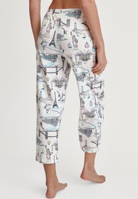 Pantalons de pyjama en coton avec un fond clair et un imprimé de paysage urbain, comprenant des monuments comme la Tour Eiffel et la Statue de la Liberté.