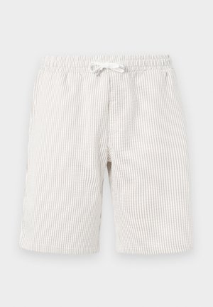 Shorts rayés beige clair avec une taille élastique et un cordon de serrage. La texture semble douce et le tissu présente un léger motif vertical.