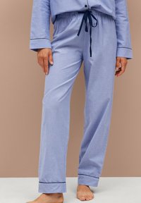 Lichtblauwe pyjamabroek met een trekkoord in de taille, omgeslagen pijpen en een zachte textuur. Heeft een relaxte pasvorm en minimale designelementen.