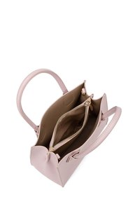 Sac à main rose clair en simili cuir avec deux poignées, poche intérieure zippée et texture lisse. Le haut ouvert révèle un compartiment principal spacieux.