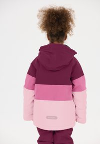 Kleurrijke jas met een kleurblokontwerp in diep paars, roze en lichtroze. Inclusief een capuchon en een zichtbaar merklogo op de onderrug.