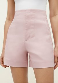 Pantalones cortos de talle alto en color rosa con una textura suave, que cuentan con bolsillos laterales y costuras precisas a lo largo de las costuras. Diseñados para un ajuste ceñido.