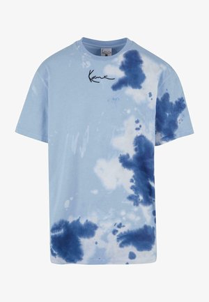 Jasnoniebieska bawełniana koszulka z wzorem tie-dye w różnych odcieniach niebieskiego, z czarnym nadrukowanym logo na górnym lewym rogu.