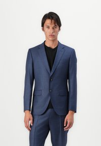 Chaqueta de traje a cuadros azul marino con dos botones, solapas con muesca y dos bolsillos delanteros, combinada con pantalones a juego.