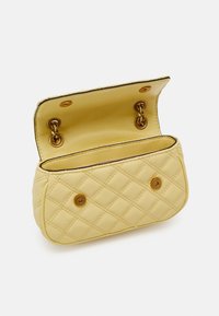 Gul quiltad handväska gjord av läder, med en vikbar design, guldfärgad hårdvara och en snap-stängning. Insidan är klädd i matchande material.