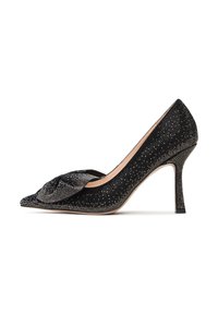 Scarpa con tacco a stiletto nero, dalla punta affusolata e con un nodo decorativo sulla tomaia, caratterizzata da una superficie strutturata con embellissements scintillanti.