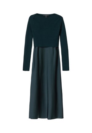 Donkergroene, langärmelig, cropped gebreide trui over een bijpassende lange satijnen rok, weergegeven tegen een witte achtergrond.