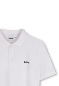 Polo bianco con colletto, maniche corte, patta con quattro bottoni, tessuto testurizzato e logo "BOSS" nero sul petto.