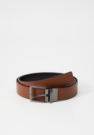 Ceinture en cuir marron avec une texture lisse, ornée d'une boucle noire métallique et d'un design classique. La doublure intérieure est de couleur foncée.